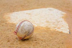 baseball and home plate in sand on the baseball field